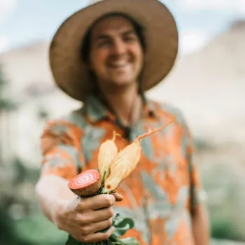 A man shows off a vegetable grown fresh at Castle Hot Springs