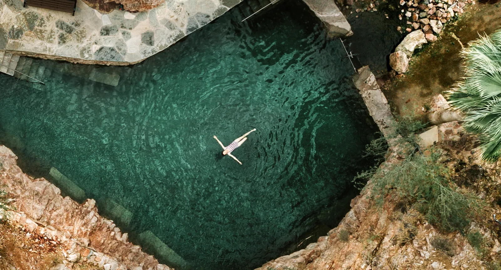 Woman practices meditation in hot springs at a luxury hot springs resort in the USA