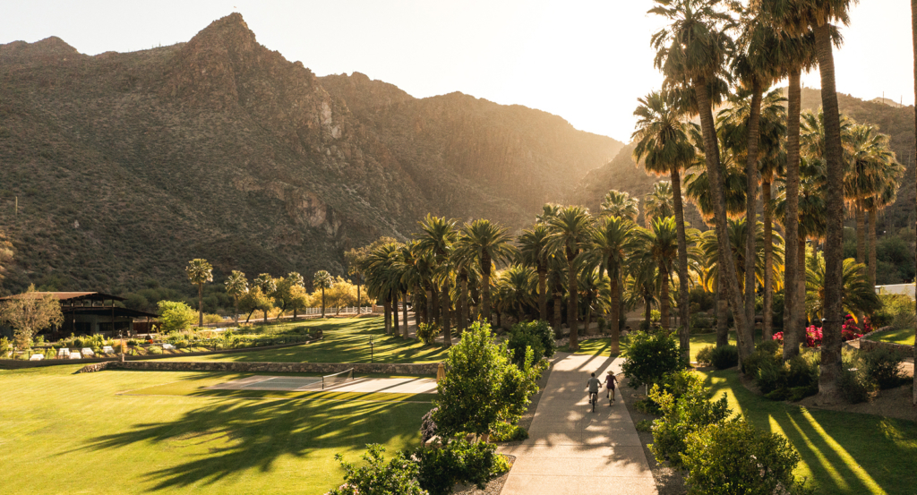 Couple on Bicycles Surrounded by Mountains and Palm Trees at an inclusive adults only resort in Arizona