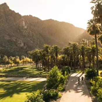 Couple on Bicycles Surrounded by Mountains and Palm Trees at an inclusive adults only resort in Arizona