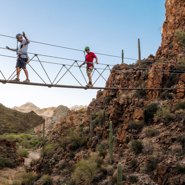Guests walking across the Via Ferrata at Arizona hot springs resort
