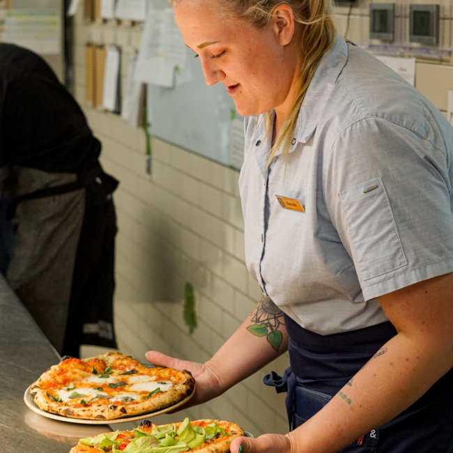 A chef holding two pizzas at Castle Hot Springs, a luxury Arizona resort