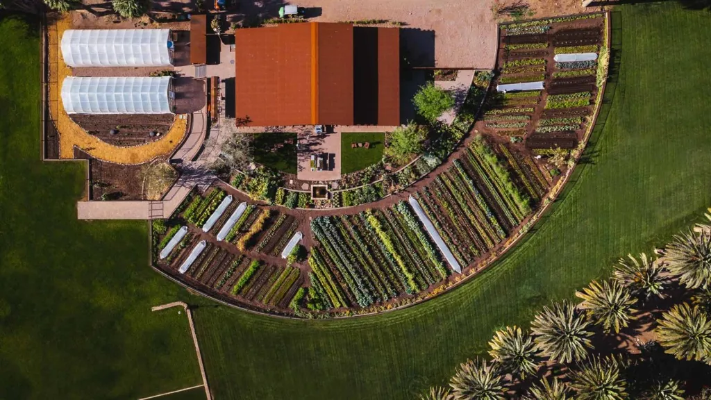 Aerial view of Castle Hot Springs circular farm with greenhouses and garden beds.