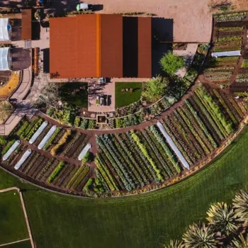 Aerial view of Castle Hot Springs circular farm with greenhouses and garden beds.