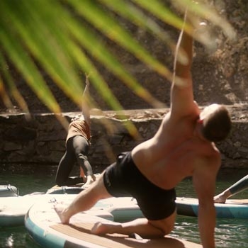 Three people enjoying paddleboard yoga