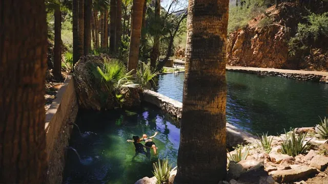 Two people in a hot spring pool performing wastsu therapy