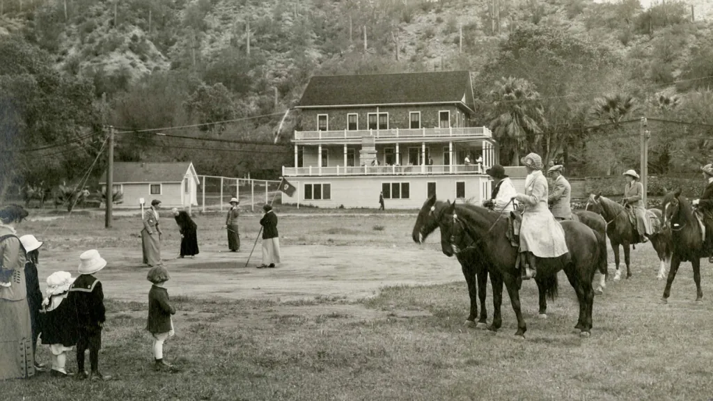 A black and white photo of a group of people riding horses at Castle Hot Springs resort