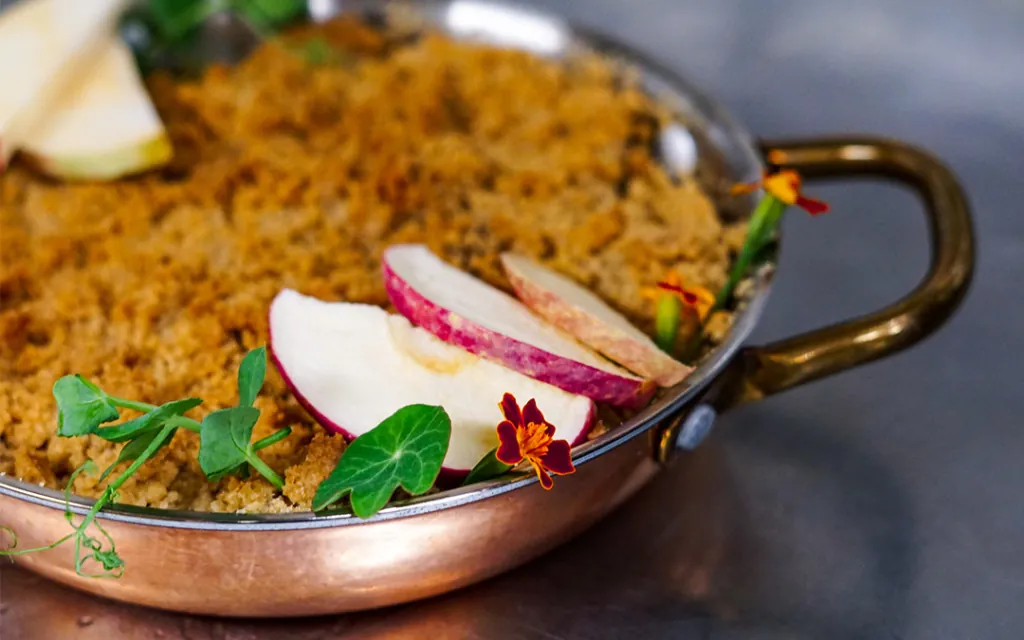 An Apple Crisp dish with apples and leaves on a table at Castle Hot Springs, a luxury resort in Arizona