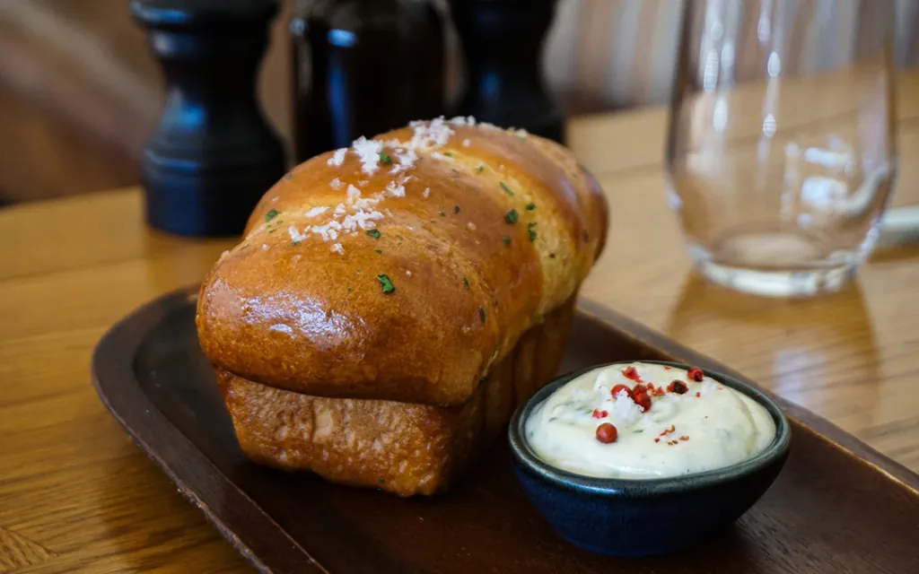 Garlic Pull Apart Rolls on a Table with Butter