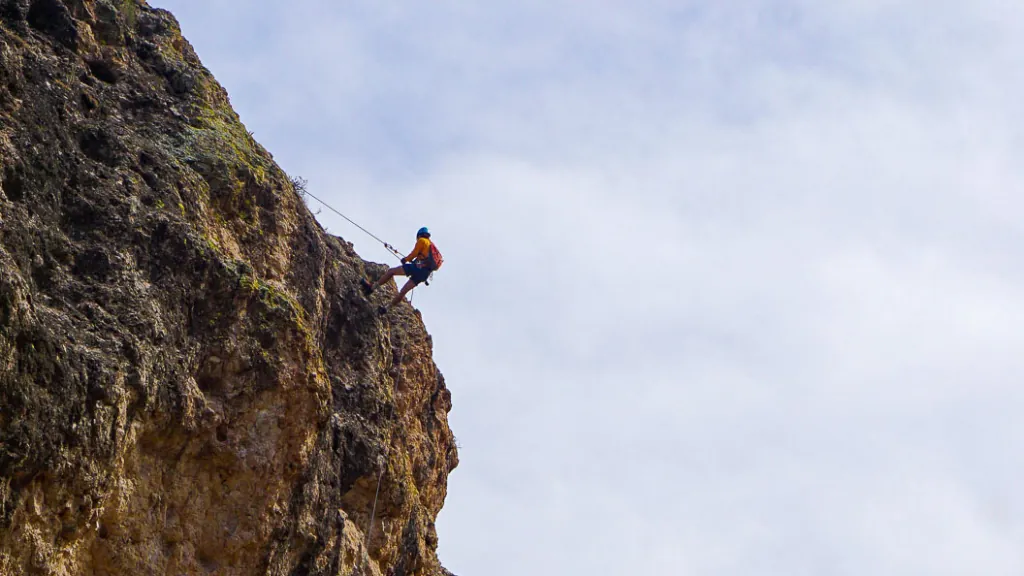Guide who is rock rappelling over a cliff in Arizona.