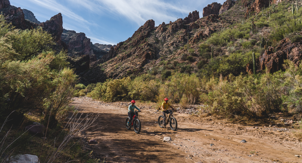 Two people riding e-bikes in the Sonoran desert