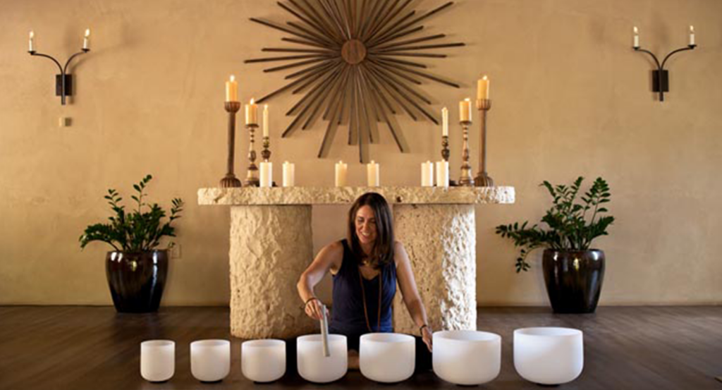 A woman facilitating a sound bath meditation during wellness activities at Castle Hot Springs.