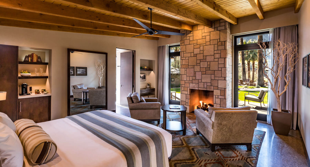 Interior of a Spring Bungalow at Castle Hot Springs, with a bed, two chairs and fireplace