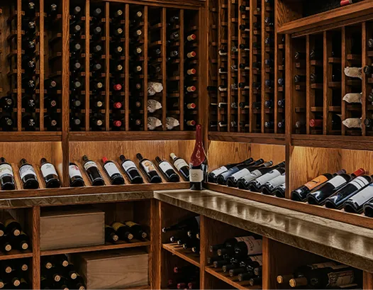 A well-lit wine cellar with wooden racks filled with bottles at Castle Hot Springs.