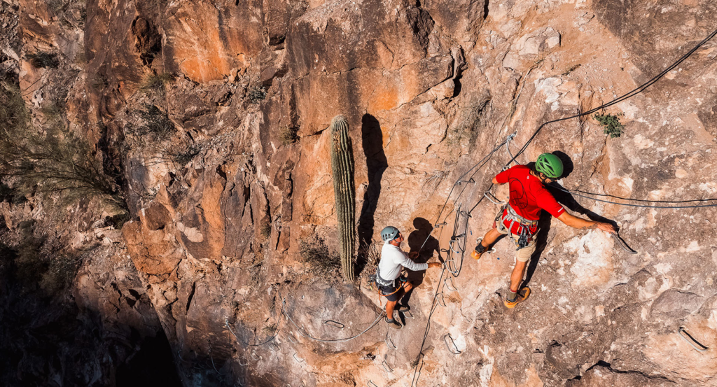 Two climbers on rock walls during an Arizona Canyon Tour
