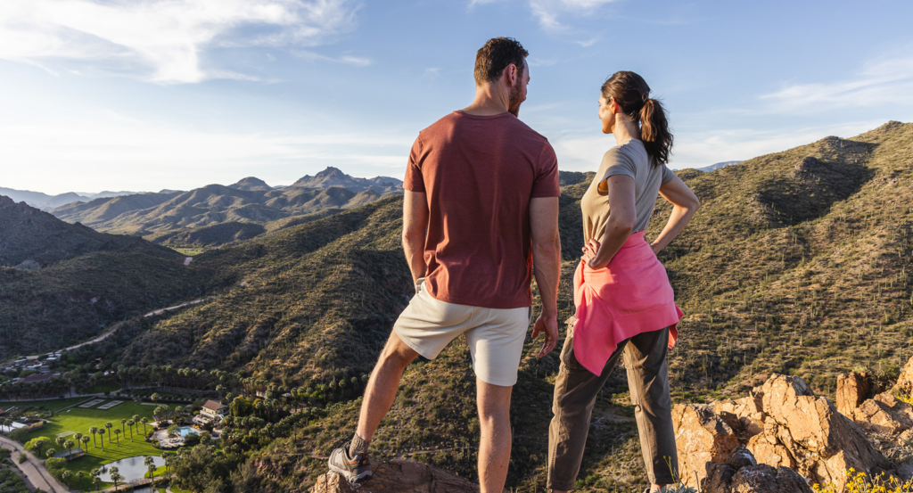 Two hikers looking down at Castle Hot Springs, a small luxury resort